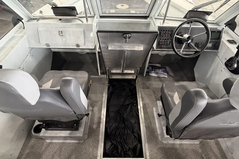 Slide: The Image of Interior of 2026 Hewescraft 221 Evolution boat, featuring dual seats and steering console. - 14