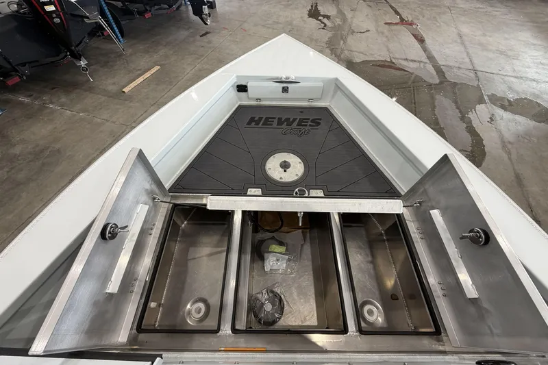 Slide: The Image of 2026 Hewescraft 221 Evolution boat storage compartments open in a showroom. - 19