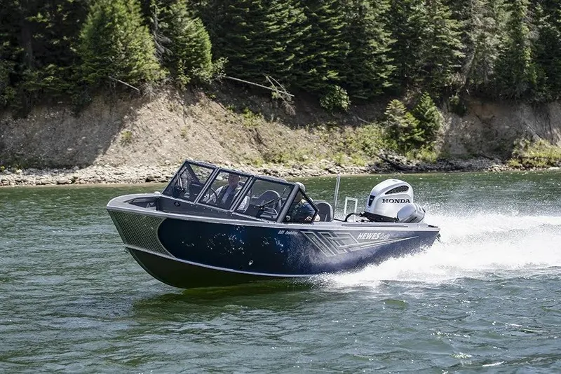 Slide: The Image of 2026 Hewescraft 221 Evolution Tournament Edition boat cruising on a scenic lake. - 22