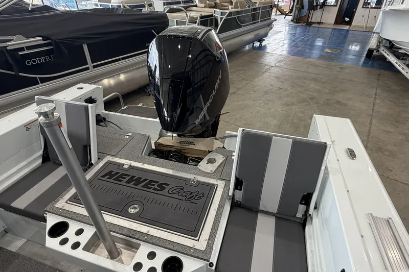 Slide: The Image of 2026 Hewescraft 221 Evolution boat interior with Mercury engine in showroom. - 5