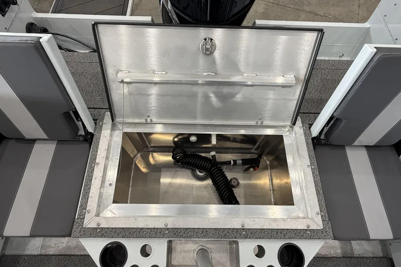 Slide: The Image of Open storage compartment on 2026 Hewescraft 221 Evolution boat, featuring gray seating and cup holders. - 7