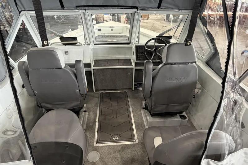 Slide: The Image of Interior of 2026 Hewescraft 221 Evolution boat, featuring seating and steering area. - 8