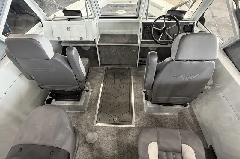 Slide: The Image of Interior of 2026 Hewescraft 221 Evolution boat, featuring seating and steering console. - 9