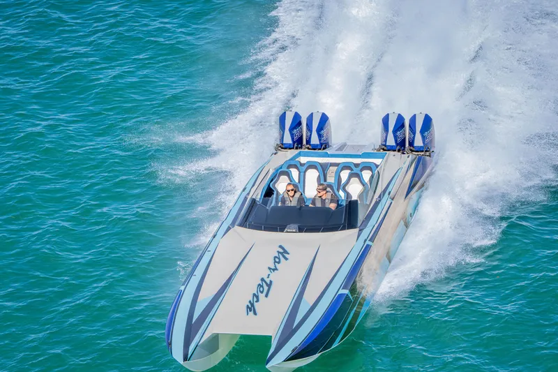 Slide: The Image of 2026 Nor-Tech 4000 Super Catamaran speeding on turquoise water, showcasing sleek design and power. - 221