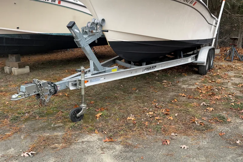 Slide: The Image of 2020 Grady-White Adventure 208 boat on Load Rite trailer, parked on leaf-covered ground. - 12