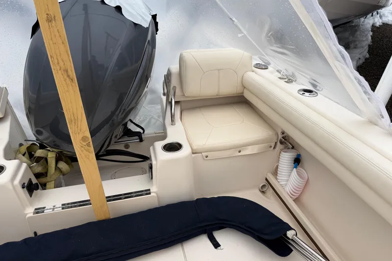 Slide: The Image of 2020 Grady-White Adventure 208 boat interior with seating and motor, covered in protective wrap. - 21