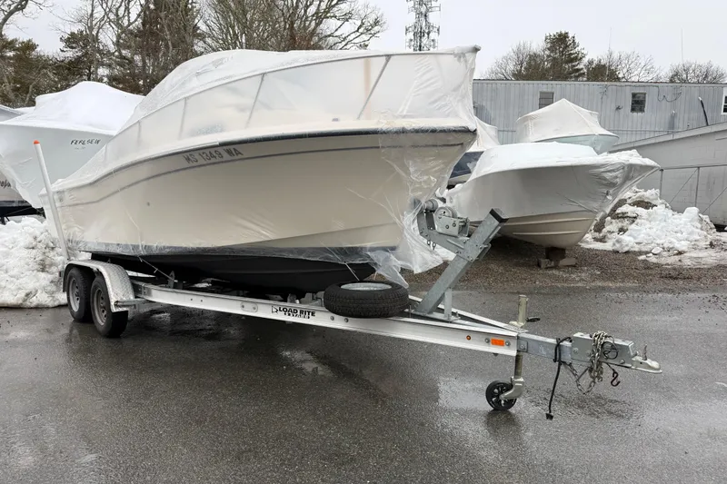 Slide: The Image of 2020 Grady-White Adventure 208 boat on trailer, covered in protective wrap, parked outdoors. - 23