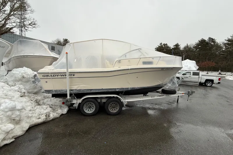 Slide: The Image of 2020 Grady-White Adventure 208 boat on trailer, covered in protective wrap, parked outdoors. - 24