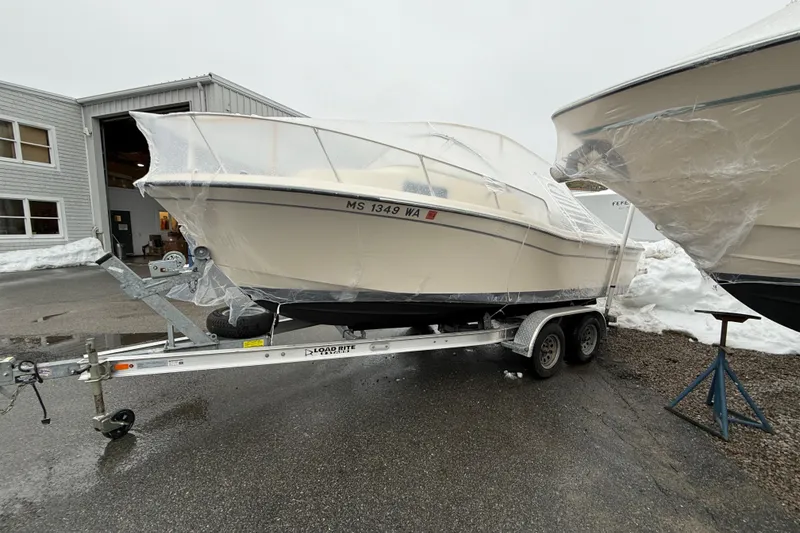 Slide: The Image of 2020 Grady-White Adventure 208 boat on trailer, covered, parked outside a building. - 26