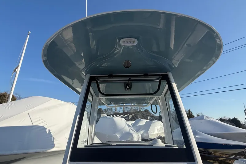 Slide: The Image of 2026 Sea Hunt Ultra 255 SE boat with sleek T-top design under clear blue sky. - 6