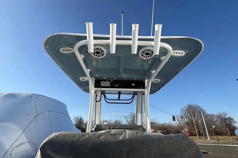 Slide: The Image of 2026 Sea Hunt Ultra 255 SE boat with T-top and rod holders under clear blue sky. - 9