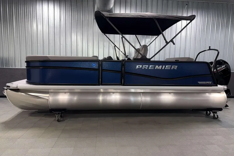 Slide: The Image of 2026 Premier 200 Sunscape RL Tritoon boat with blue exterior and canopy in showroom. - 4