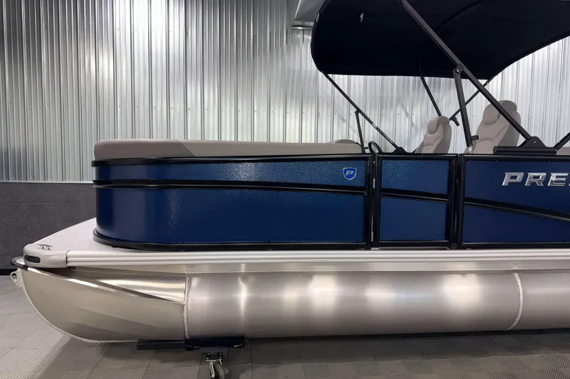 Slide: The Image of 2026 Premier 200 Sunscape RL Tritoon, blue exterior, in a showroom setting. - 5