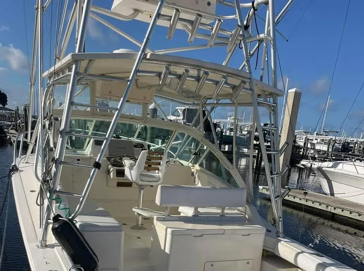 Slide: The Image of 2005 Albemarle 310 Sport Fisherman boat docked at marina under clear blue sky. - 15