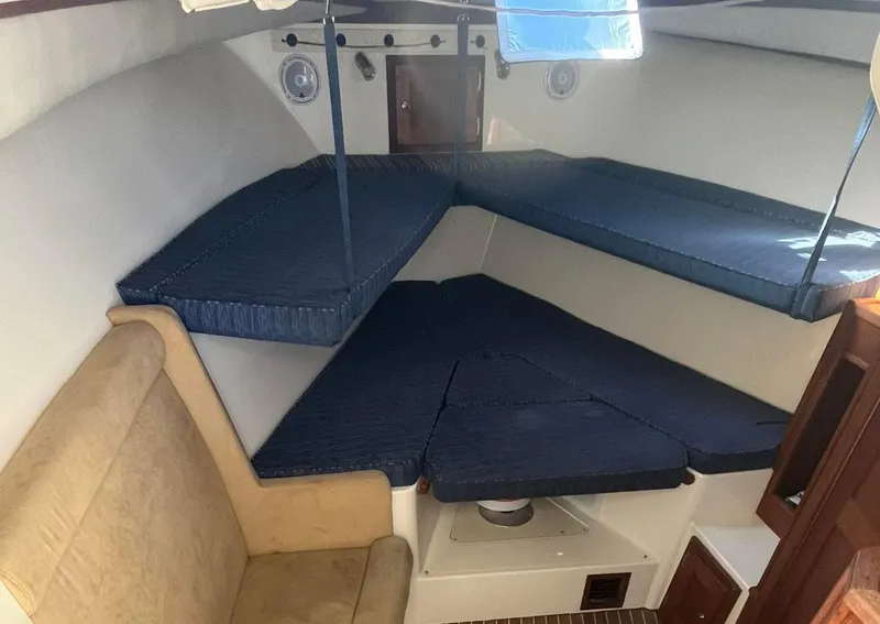 Slide: The Image of 2005 Albemarle 310 Sport Fisherman cabin interior with blue cushions and beige seating. - 6