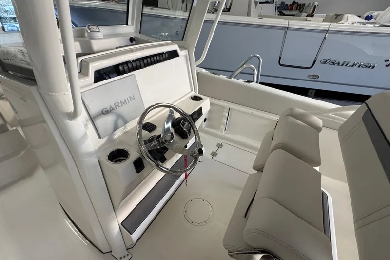 Slide: The Image of 2026 Sailfish 252 CC boat interior with Garmin navigation system and dual seating. - 10