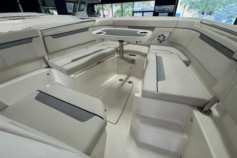 Slide: The Image of 2026 Sailfish 252 CC boat interior with cushioned seating and table setup. - 9