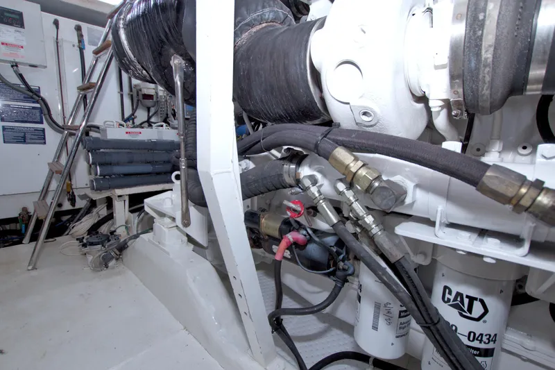 Slide: The Image of Engine room of a 2005 Neptunus 62 Flybridge yacht, featuring mechanical components and CAT filters. - 108