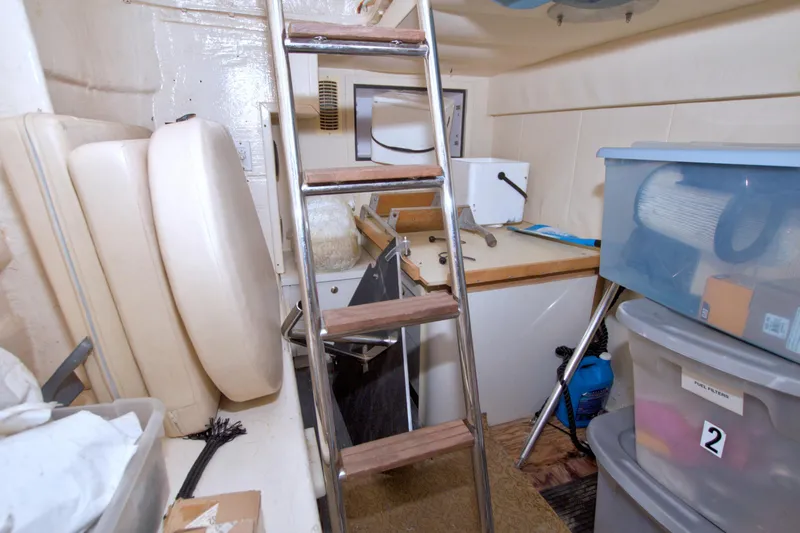 Slide: The Image of Storage area in a 2005 Neptunus 62 Flybridge yacht with ladder and containers. - 122