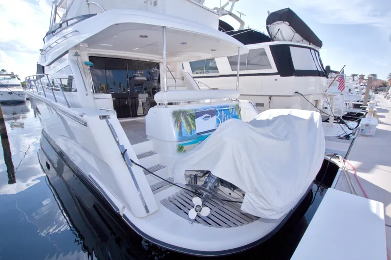 Slide: The Image of 2005 Neptunus 62 Flybridge yacht docked at marina, covered equipment on deck. - 126