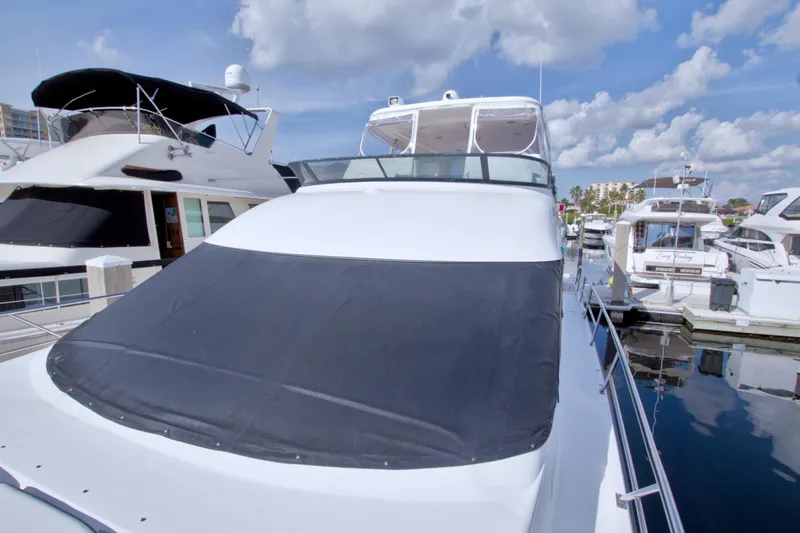 Slide: The Image of 2005 Neptunus 62 Flybridge yacht docked at marina under blue sky. - 14