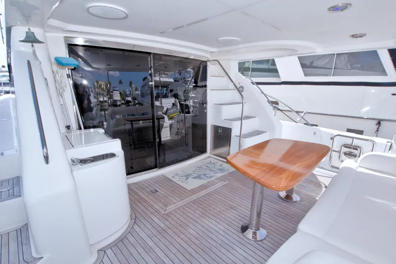 Slide: The Image of 2005 Neptunus 62 Flybridge yacht deck with wooden table and seating area. - 17