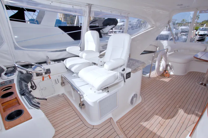 Slide: The Image of Luxurious 2005 Neptunus 62 Flybridge yacht interior with white seating and wooden flooring. - 24