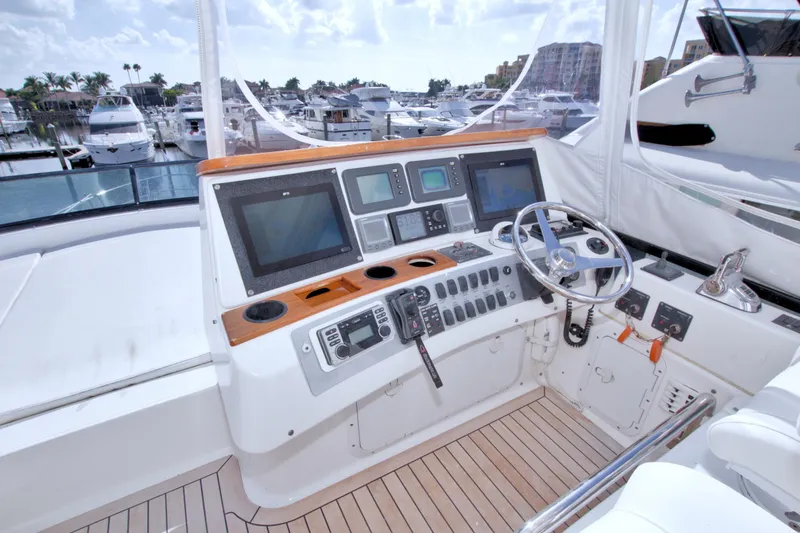 Slide: The Image of 2005 Neptunus 62 Flybridge yacht helm with navigation controls and steering wheel. - 26