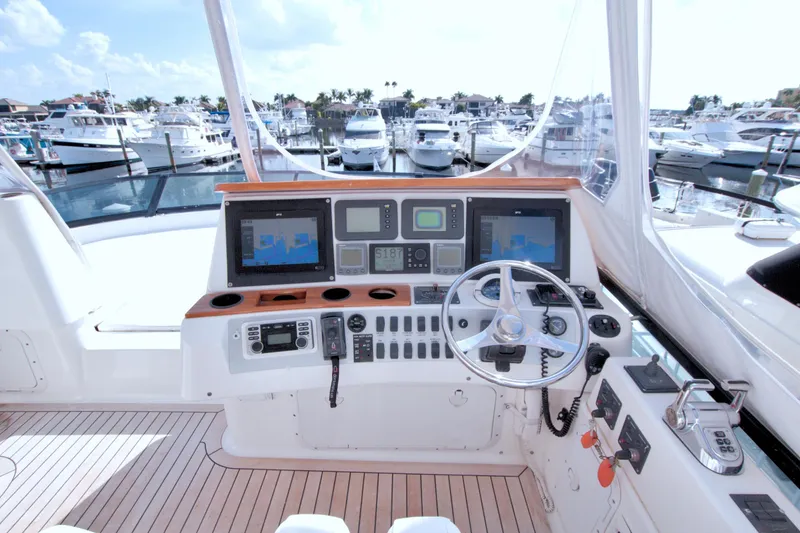 Slide: The Image of 2005 Neptunus 62 Flybridge yacht helm with advanced navigation systems and marina view. - 27
