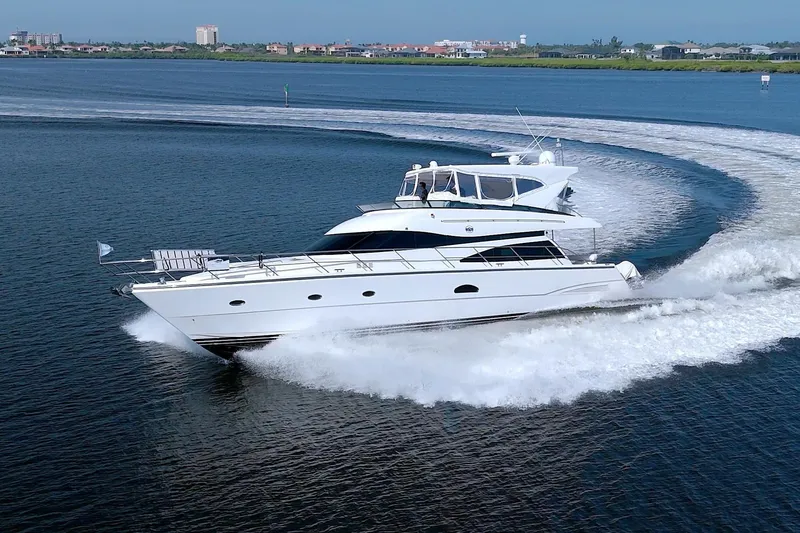 Slide: The Image of 2005 Neptunus 62 Flybridge yacht cruising on open water, creating a dynamic wake. - 4