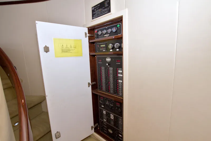 Slide: The Image of Electrical panel inside 2005 Neptunus 62 Flybridge yacht, with open door and visible controls. - 54