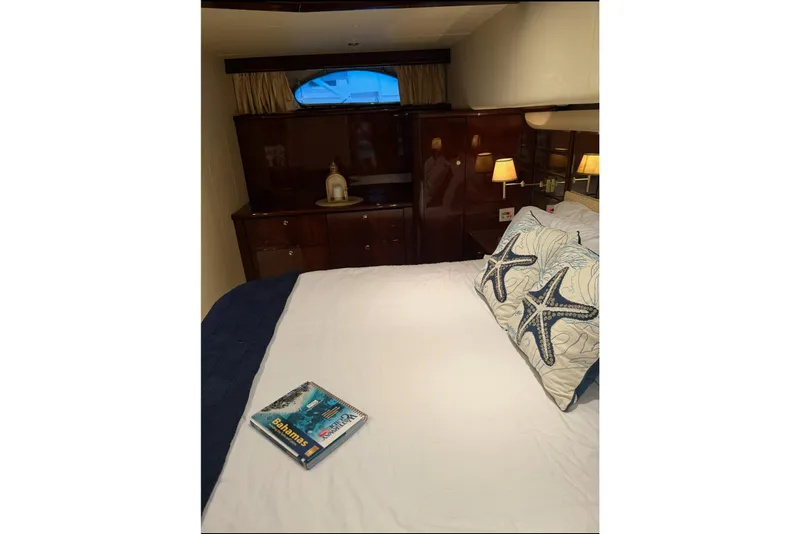 Slide: The Image of Luxurious 2005 Neptunus 62 Flybridge yacht bedroom with starfish pillows and a book. - 85