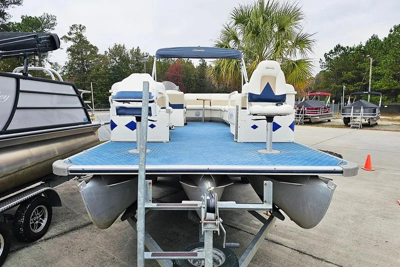 Slide: The Image of 2004 Bentley Pontoons 240 Fish pontoon boat on trailer, blue deck, outdoor setting. - 2