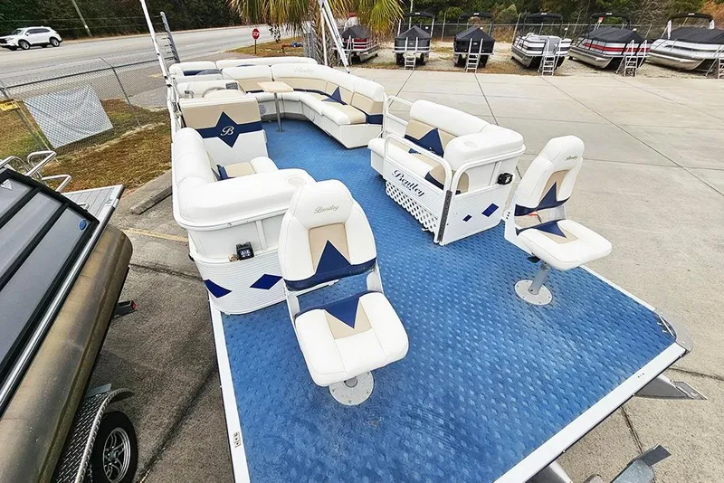 Slide: The Image of 2004 Bentley Pontoons 240 Fish with blue flooring and white seating, displayed outdoors. - 7