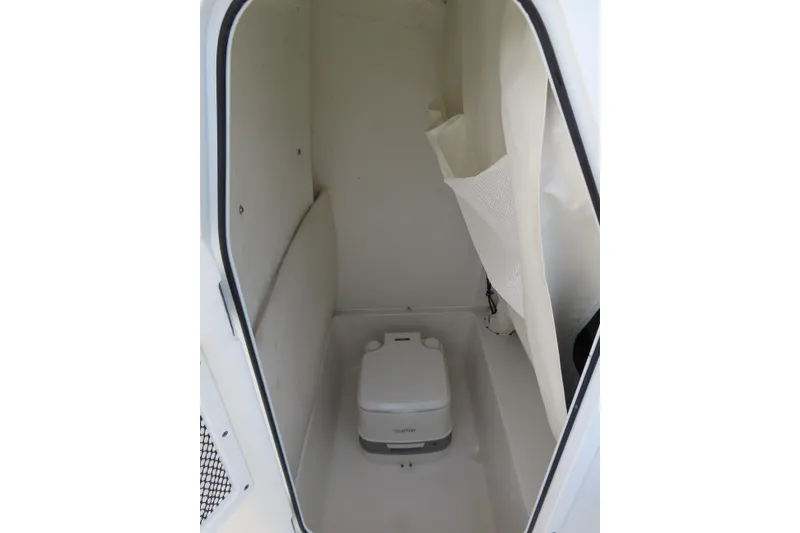 Slide: The Image of 2019 Sea Hunt Ultra 234 boat interior with compact portable toilet. - 20