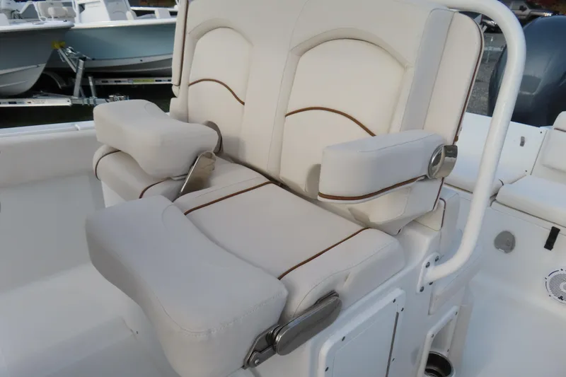 Slide: The Image of 2019 Sea Hunt Ultra 234 boat seating with cushioned armrests and white upholstery. - 23