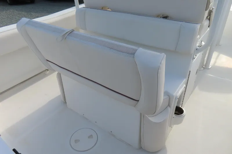 Slide: The Image of 2019 Sea Hunt Ultra 234 boat interior with white cushioned seating and storage. - 31