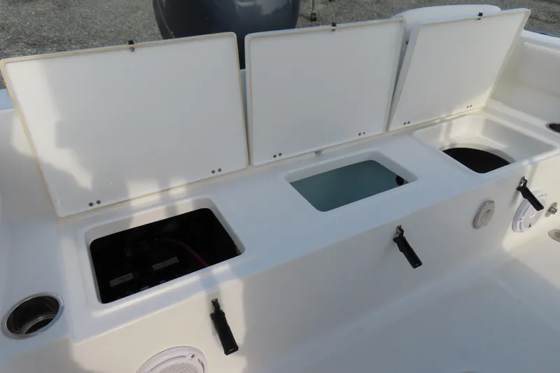 Slide: The Image of 2019 Sea Hunt Ultra 234 boat storage compartments with open lids, showcasing interior features. - 35