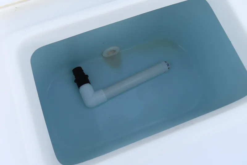 Slide: The Image of Livewell tank in 2019 Sea Hunt Ultra 234 boat, featuring a white drainage pipe. - 37