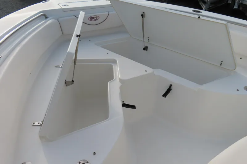 Slide: The Image of 2019 Sea Hunt Ultra 234 boat storage compartments with open hatches, showcasing spacious interior. - 9