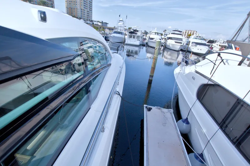 Slide: The Image of 2019 Beneteau Gran Turismo 50 yacht docked in a marina, surrounded by other boats. - 18