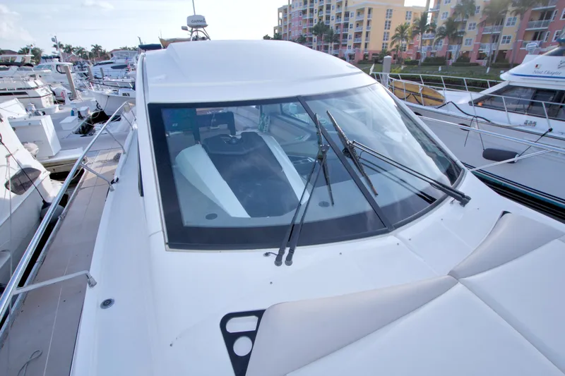 Slide: The Image of 2019 Beneteau Gran Turismo 50 yacht docked at marina, showcasing sleek design and windshield. - 19