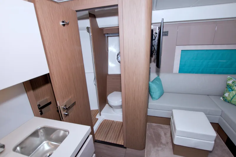 Slide: The Image of 2019 Beneteau Gran Turismo 50 interior with bathroom, sink, and seating area. - 51