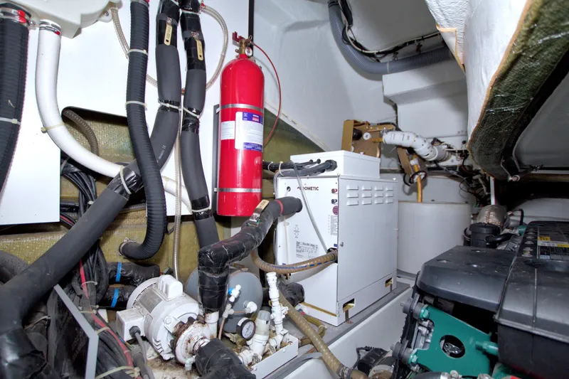 Slide: The Image of Engine room of 2019 Beneteau Gran Turismo 50 with equipment and fire extinguisher. - 85
