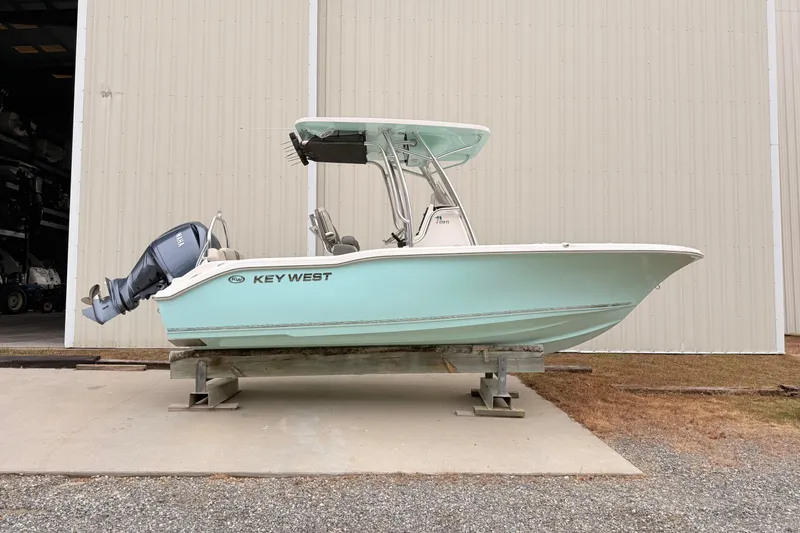 The Image of 2026 Key West 219 FS boat on display outside a large storage building. - 0