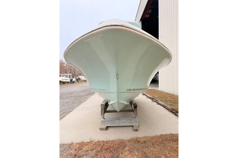 Slide: The Image of 2026 Key West 219 FS boat on trailer, front view near storage facility. - 1