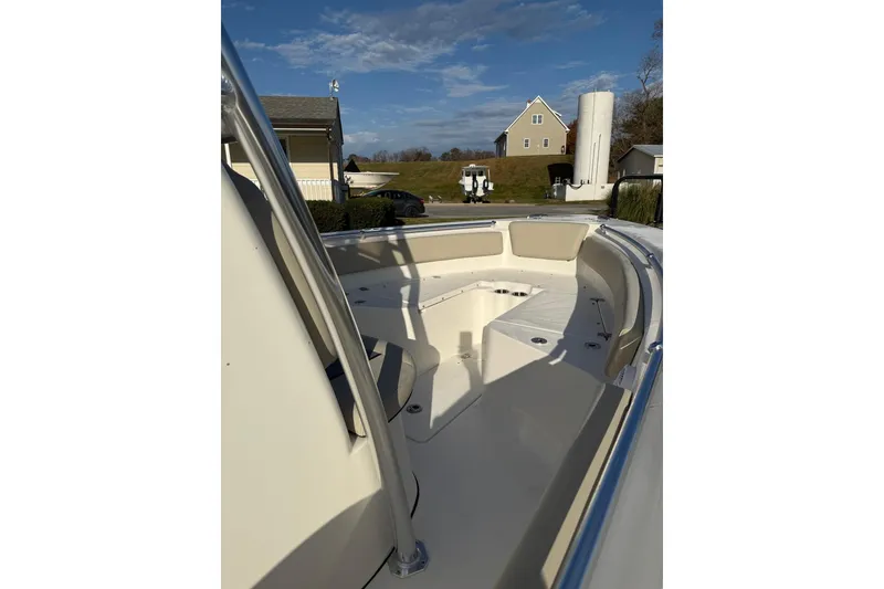 Slide: The Image of 2026 Key West 219 FS boat interior with seating and storage, under a clear blue sky. - 3