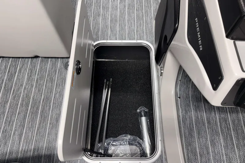 Slide: The Image of Open storage compartment in 2026 Premier 210 Sunsation RF Tritoon boat with accessories inside. - 16