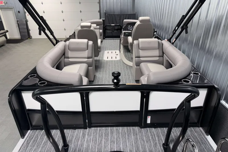 Slide: The Image of 2026 Premier 210 Sunsation RF Tritoon with luxurious seating and modern design in a showroom. - 8