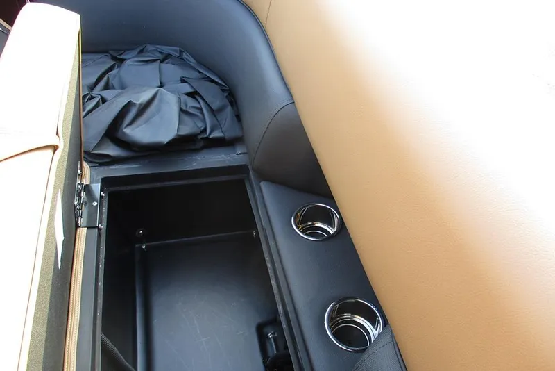 Slide: The Image of 2026 Bentley Pontoons Elite 223 Admiral interior storage with cup holders and tan upholstery. - 18